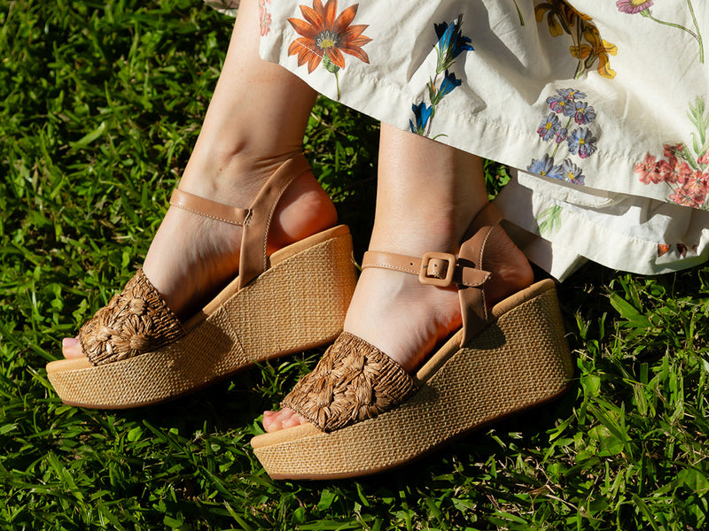 Yizzy wedge sandal in toast raffia on a model